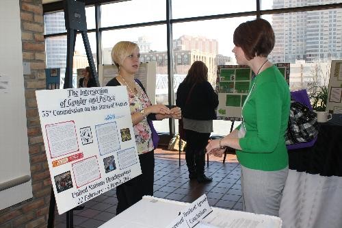 Student explains poster to Women's Center staff member